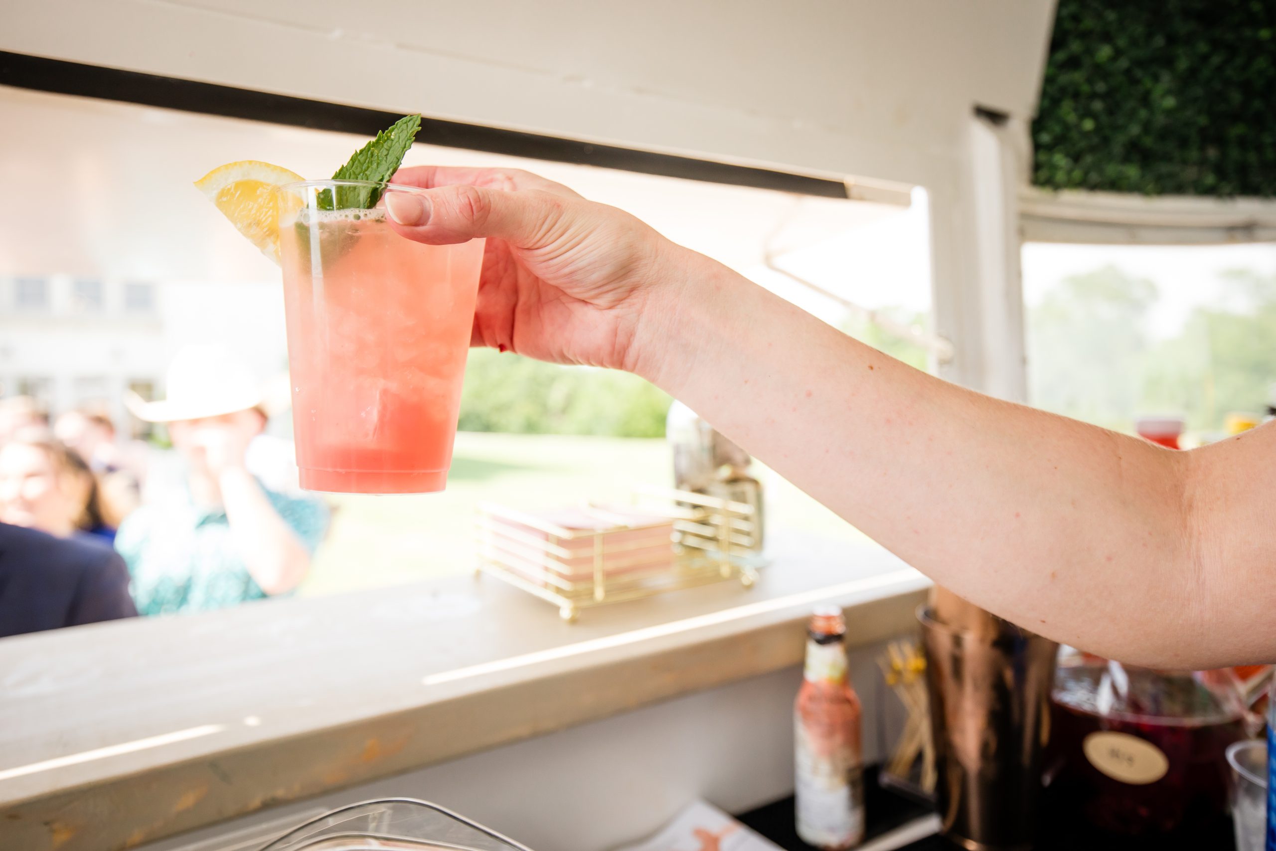 A hand holding a garnished signature cocktail